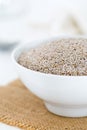 Whole, organic white chia seeds heap in white bowl with bright kitchen background