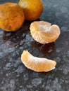 Whole peeled and unpeeled orange fruit and slice and dark background