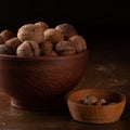 Whole and peeled walnuts in ceramic and wooden dishes