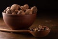 Whole and peeled walnuts in ceramic and wooden dishes