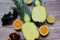 Whole pineapple cut in half, two pieces of pineapple halves, pineapple fruit on wooden background, yellow fruit Royalty Free Stock Photo