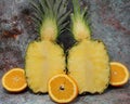 Whole pineapple cut in half, two pieces of pineapple halves, vertically cut pineapple, standing pineapple on a marbled background Royalty Free Stock Photo