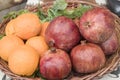 Whole pomegranates and oranges in knitted bowl