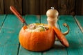 Whole pumpkin stuffed with rice and meat on turquoise table Royalty Free Stock Photo