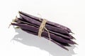 Whole purple raw green bean pods tied with string