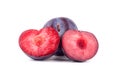 Purple ripe plums whole and one cutted plum red inside on white background isolated close up macro in row in water drops