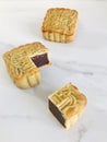 A whole and quarter-cut mooncake on white marble background. Royalty Free Stock Photo