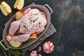 Whole raw chicken with ingredients for making rose pepper, lemon, thyme, garlic, cherry tomato, sorrel, apples, salt in the Royalty Free Stock Photo