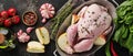 Whole raw chicken with ingredients for making rose pepper, lemon, thyme, garlic, cherry tomato, sorrel, with apples and salt on Royalty Free Stock Photo