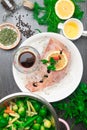 Whole raw organic fish sea perch on ice cubes in white plate on a dark table background with black pepper, olive oil, dill, cilant Royalty Free Stock Photo