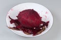 Whole raw peeled red beetroot among the peelings in bowl