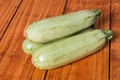 Whole raw zucchini on the wooden mahogany board planks