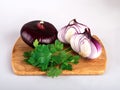 A whole red flat onion on a cutting Board with parsley leaves isolated on a white background