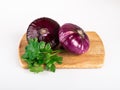 A whole red flat onion on a cutting Board with parsley leaves isolated on a white background