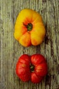 Whole red and yellow heirloom tomatoes on rustic wood tabletop Royalty Free Stock Photo