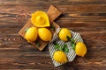 Whole ripe lemons and juicer on wooden table