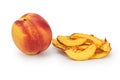 A whole ripe nectarine next to a pile of dried slices of this fruit on a white background Royalty Free Stock Photo