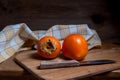 Whole ripe persimmon on a wooden background