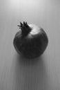 Whole ripe pomegranate on the wooden sunny table, bw