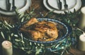 Whole roasted chicken with garlic decorated with olive tree branch Royalty Free Stock Photo