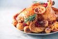 Whole roasted chicken with oranges, cranberries, spices and herbs. Copy space. Friends or family dinner. Festive Christmas table. Royalty Free Stock Photo