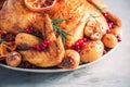 Whole roasted chicken with oranges, cranberries, spices and herbs. Copy space. Friends or family dinner. Festive Christmas table. Royalty Free Stock Photo