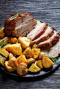 Whole roasted pork loin with baked potato wedges Royalty Free Stock Photo