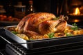 Whole roasted turkey with crispy brown skin in a stainless steel roasting pan on the stovetop resting before Thanksgiving dinner