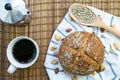 Whole rye bread, mixed nuts and sunflower seeds on white cloth with stripe with moka pot and a cup of coffee. Royalty Free Stock Photo