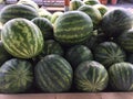 Whole sized Watermelons in bin at farm stand.