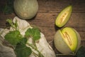 Whole and Slice of Melons with Leaves on wooden background, yellow melon or cantaloupe melon with seeds isolated on wooden backgro Royalty Free Stock Photo