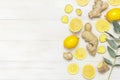 Whole and sliced fresh lemon, ginger root, eucalyptus leaves on white wooden background. Flat lay top view copy space Royalty Free Stock Photo