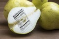 Whole and sliced green pears with nutrtional label on wooden boa Royalty Free Stock Photo