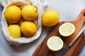 Whole and sliced lemons on a wooden board next to a knife Royalty Free Stock Photo
