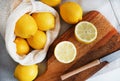 Whole and sliced lemons on a wooden board next to a knife Royalty Free Stock Photo