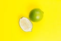 Whole and sliced llime on yellow background Royalty Free Stock Photo