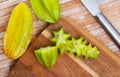 Whole and sliced star fruits on wooden surface Royalty Free Stock Photo