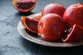 Whole and slices of blood oranges in a vintage plate on a black Royalty Free Stock Photo