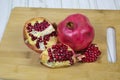 Whole and slices of red ripe pomegranate with seeds on a wooden Board. Raw organic fruits vegetables. Royalty Free Stock Photo