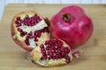 Whole and slices of red ripe pomegranate with seeds on a wooden Board. Raw organic fruits vegetables. Royalty Free Stock Photo