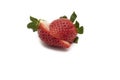 A whole strawberry with its green leaves, cut in half Royalty Free Stock Photo