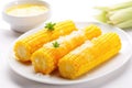 whole sweet corn with butter glaze on a white plate