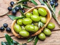 Whole table olives in the wooden bowl on the table. Royalty Free Stock Photo