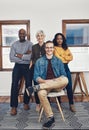 The whole team all together again. Portrait of a group of confident businesspeople seated together inside of the office Royalty Free Stock Photo