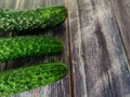 Whole three fresh cucumbers on a wooden table. Close-up Royalty Free Stock Photo