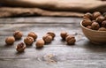 Whole walnuts in a bowl and on rustic old wooden table. Royalty Free Stock Photo