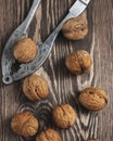 Whole walnuts with nutcracker on rustic old wooden table