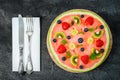 Whole watermelon pizza with fruits, dark background, top view