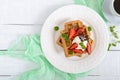 Whole wheat Belgian waffles with whipped cream, freshly chopped strawberries Royalty Free Stock Photo