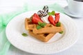 Whole wheat Belgian waffles with whipped cream, freshly chopped strawberries, mint leaves Royalty Free Stock Photo